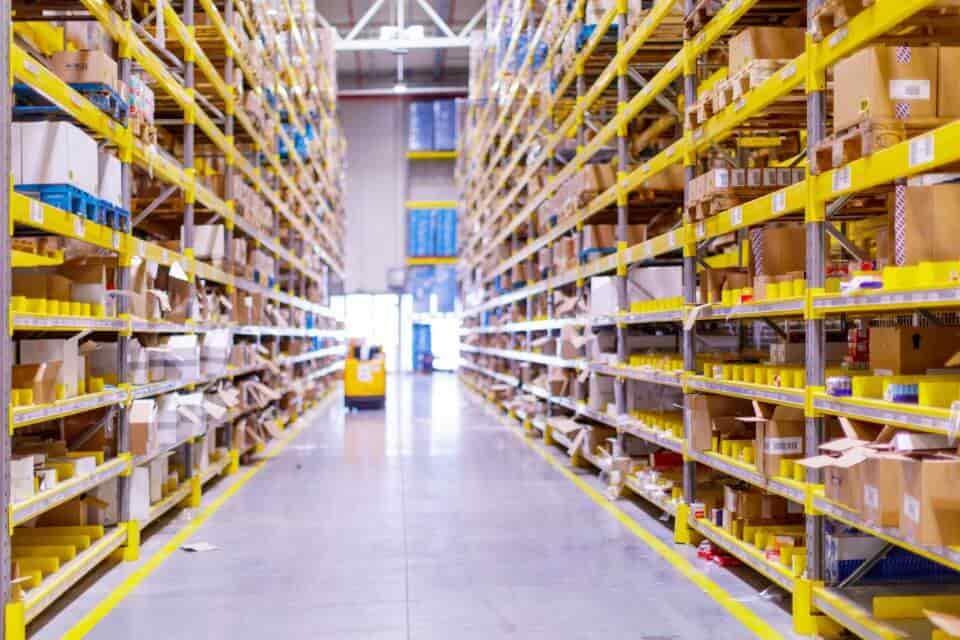 photo of a full warehouse with a pallet truck in the background