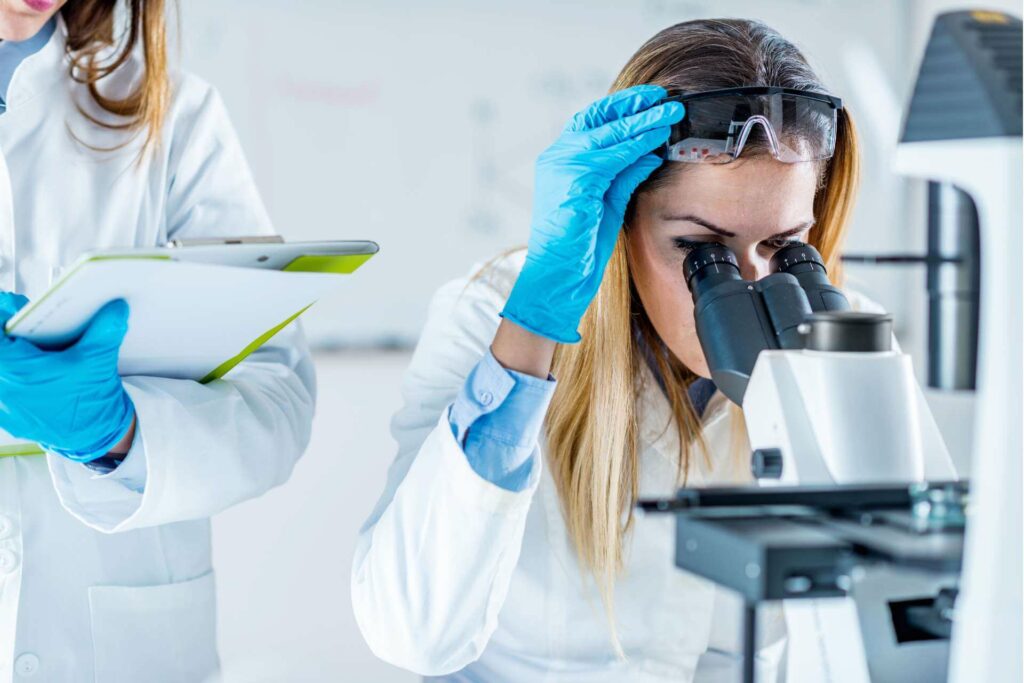 Woman in the lab using a microscope